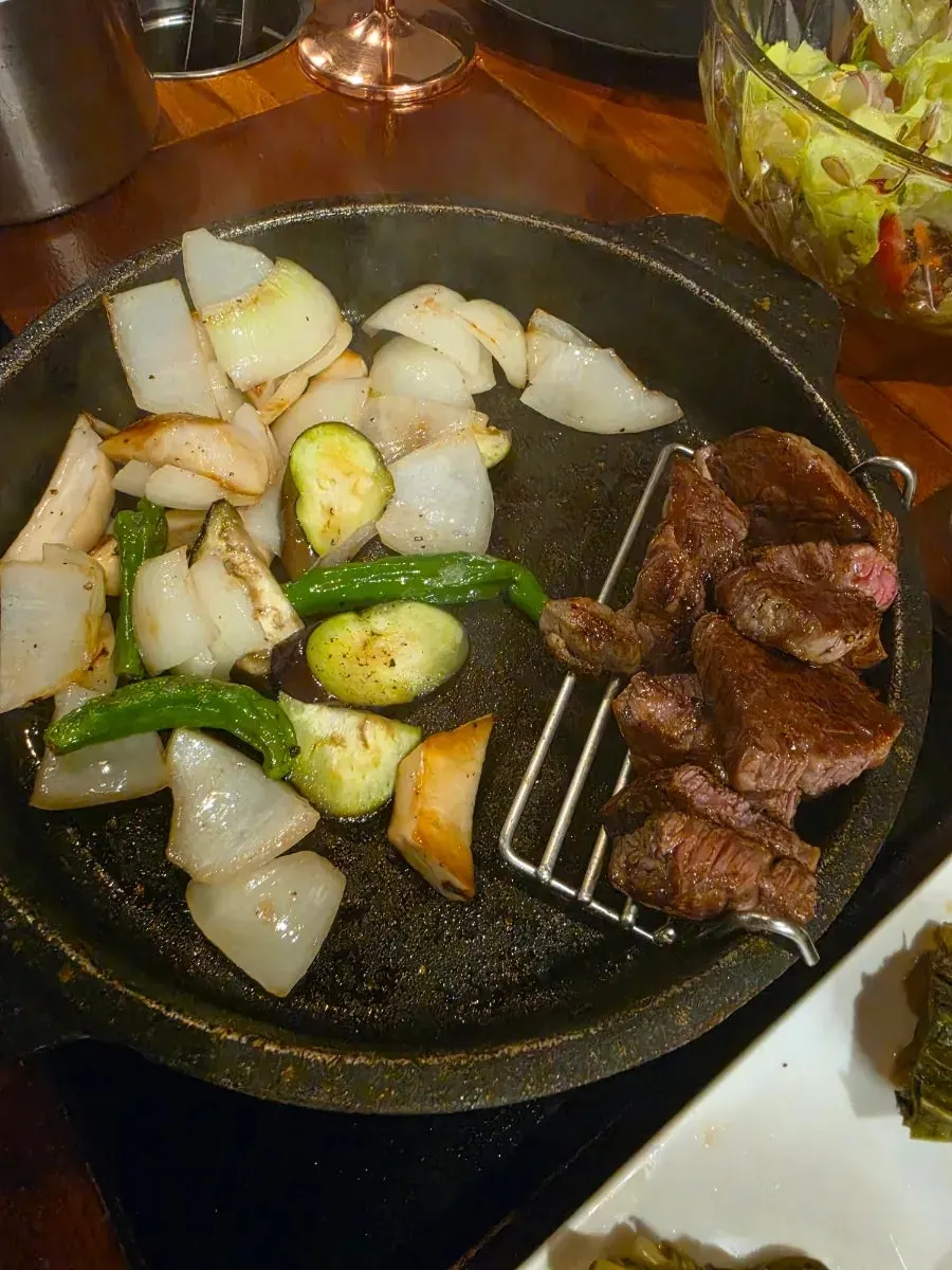 A staff member grilling meat tableside