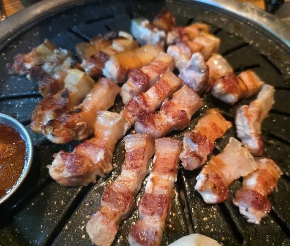 Thick Jeju black pork grilling over charcoal
