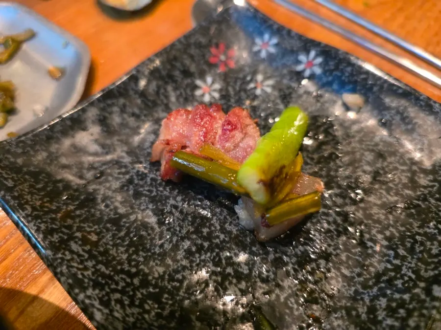 Pork belly dipped in mel-jeot bubbling at the center of the grill