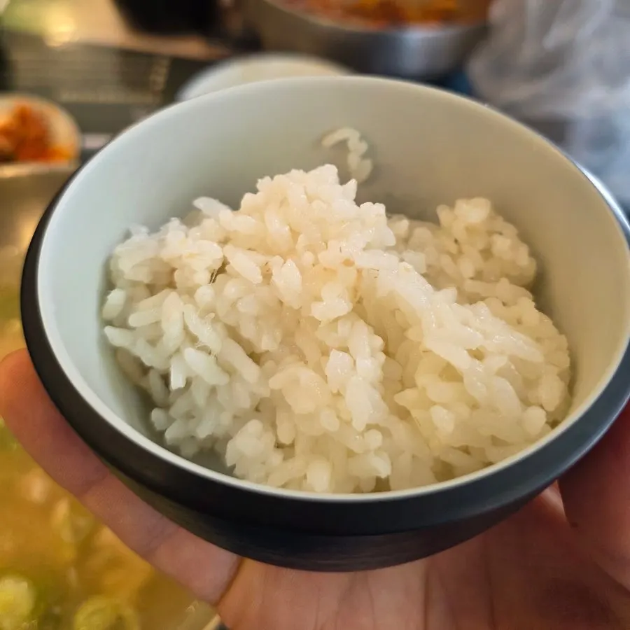 Mixing kalguksu noodles into the perilla oil sauce