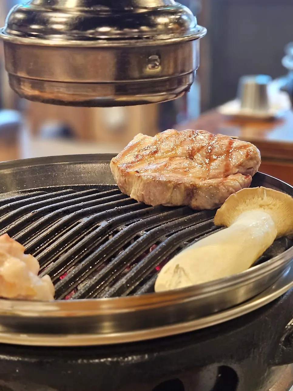 Staff member placing aged pork belly on the grill