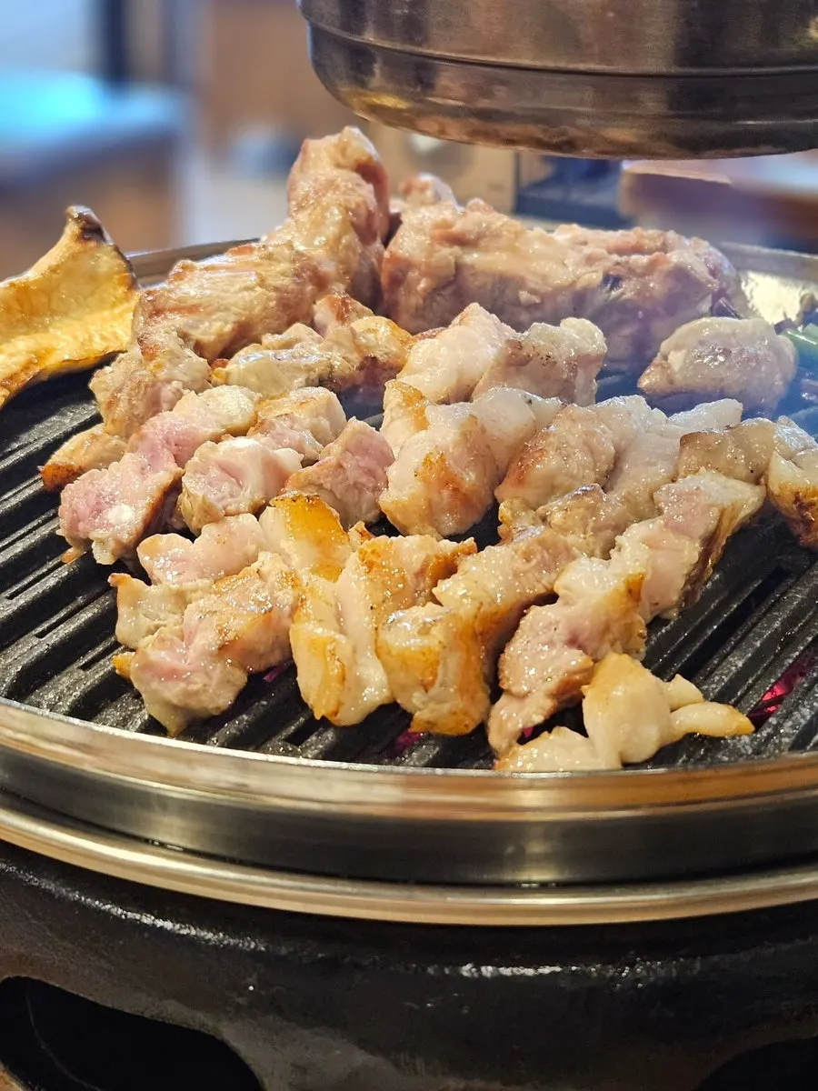 Pork belly and pork neck grilling over charcoal
