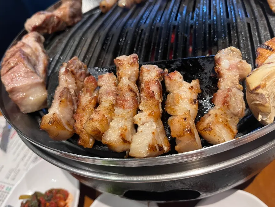 Daging dipanggang oleh staf di atas pemanggang