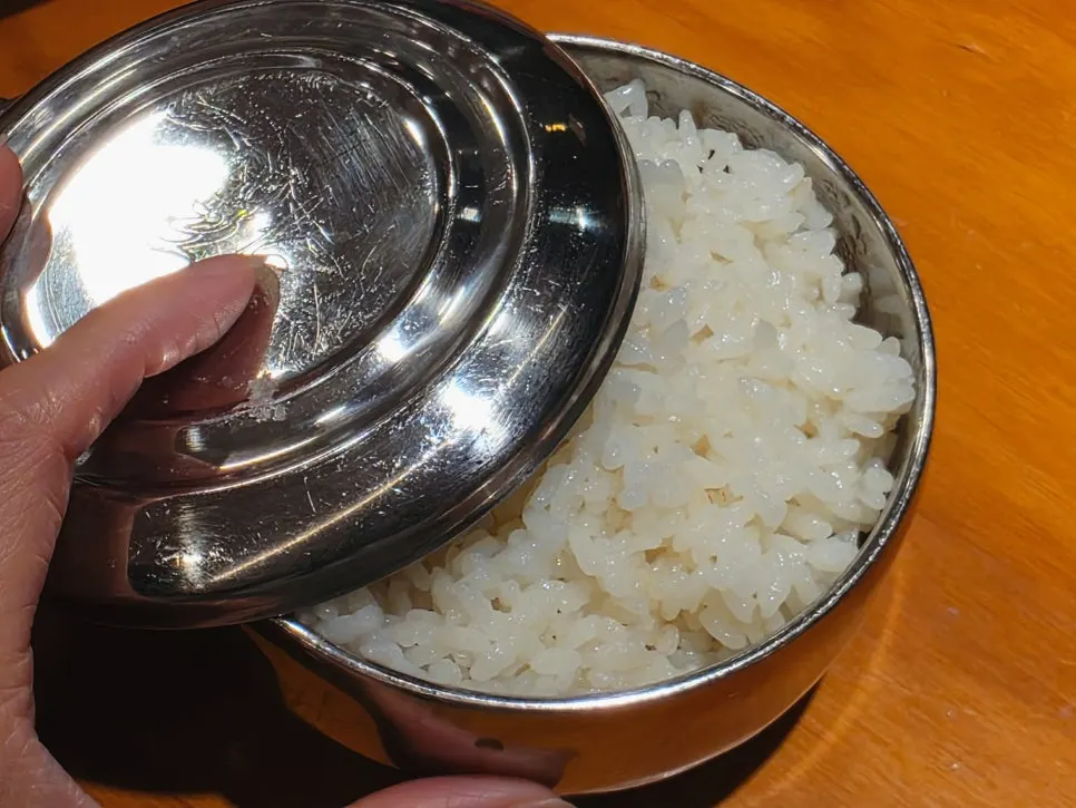 Pot of gamjatang topped with bone meat, perilla leaves, and ground perilla seeds