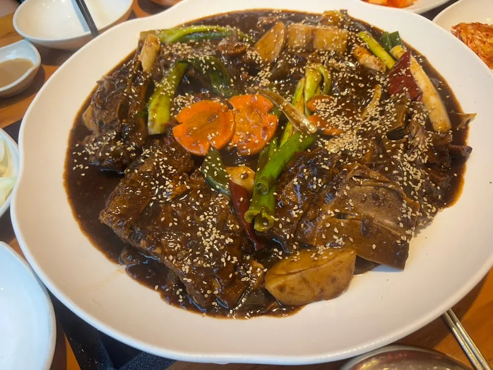 A spread of bone stew with meat, potatoes, rice cakes, and glass noodles