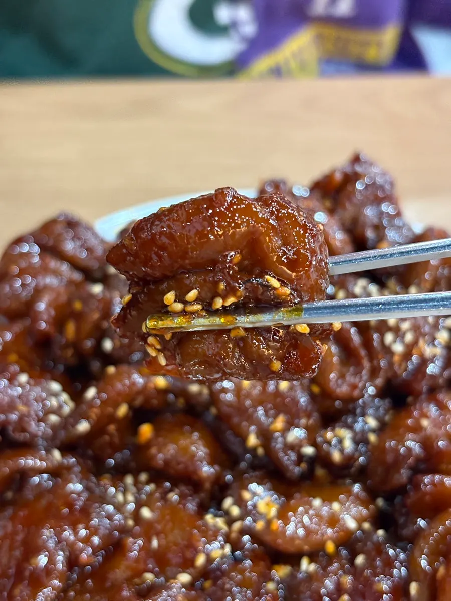 쌈채소에 올린 매운 곱창구이 한 점