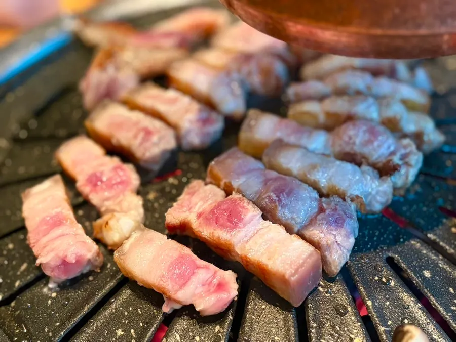 Sliced pork belly and mushrooms on the grill