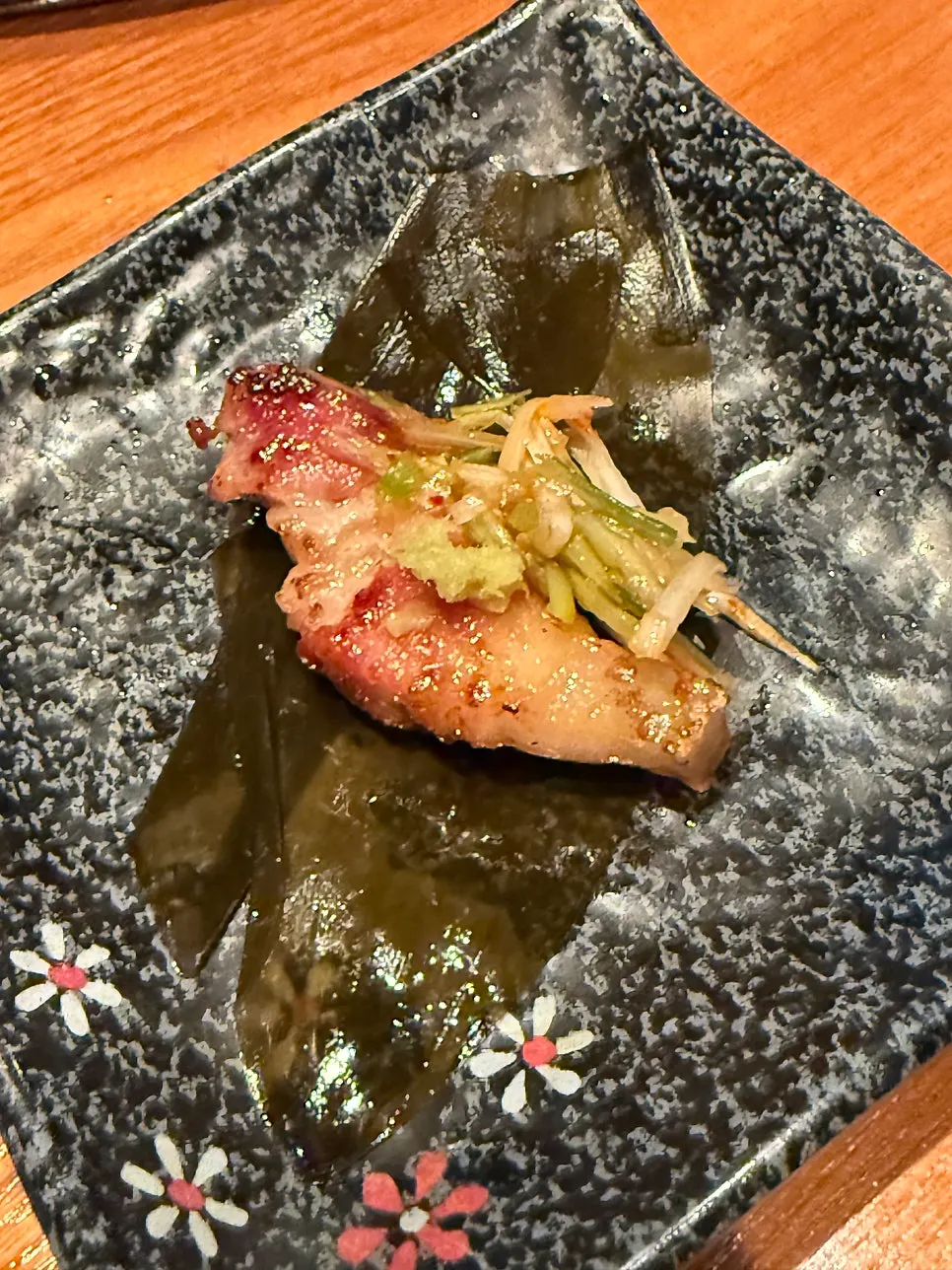 Pork placed on grilled baek kimchi with wasabi