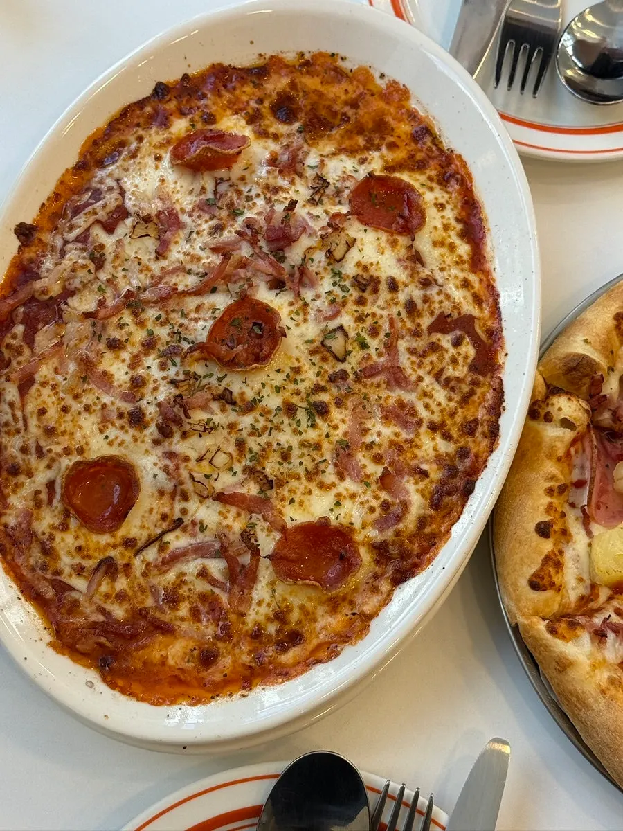 A slice of spicy pepperoni pizza topped with crushed jalapeños