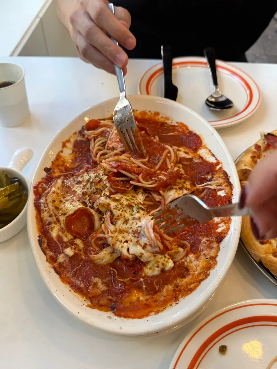 A bite of oven pasta covered in tomato sauce