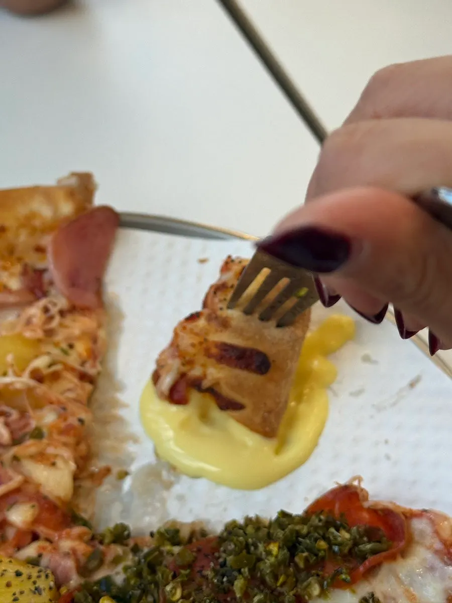 A slice of half-and-half pizza with stretchy cheese