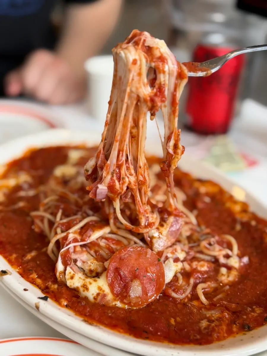 Cheese stretching as the oven pasta is lifted with a fork