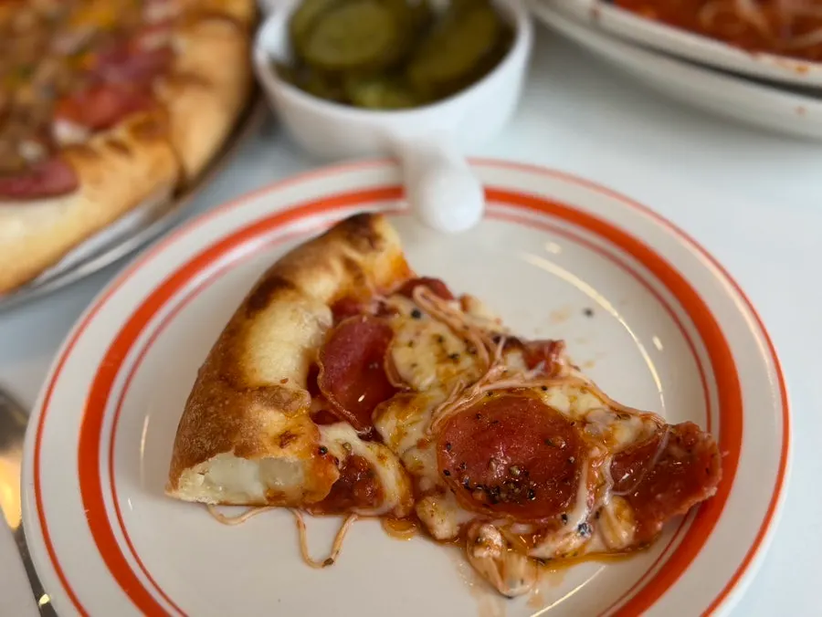 A slice of pizza with stretching cheese
