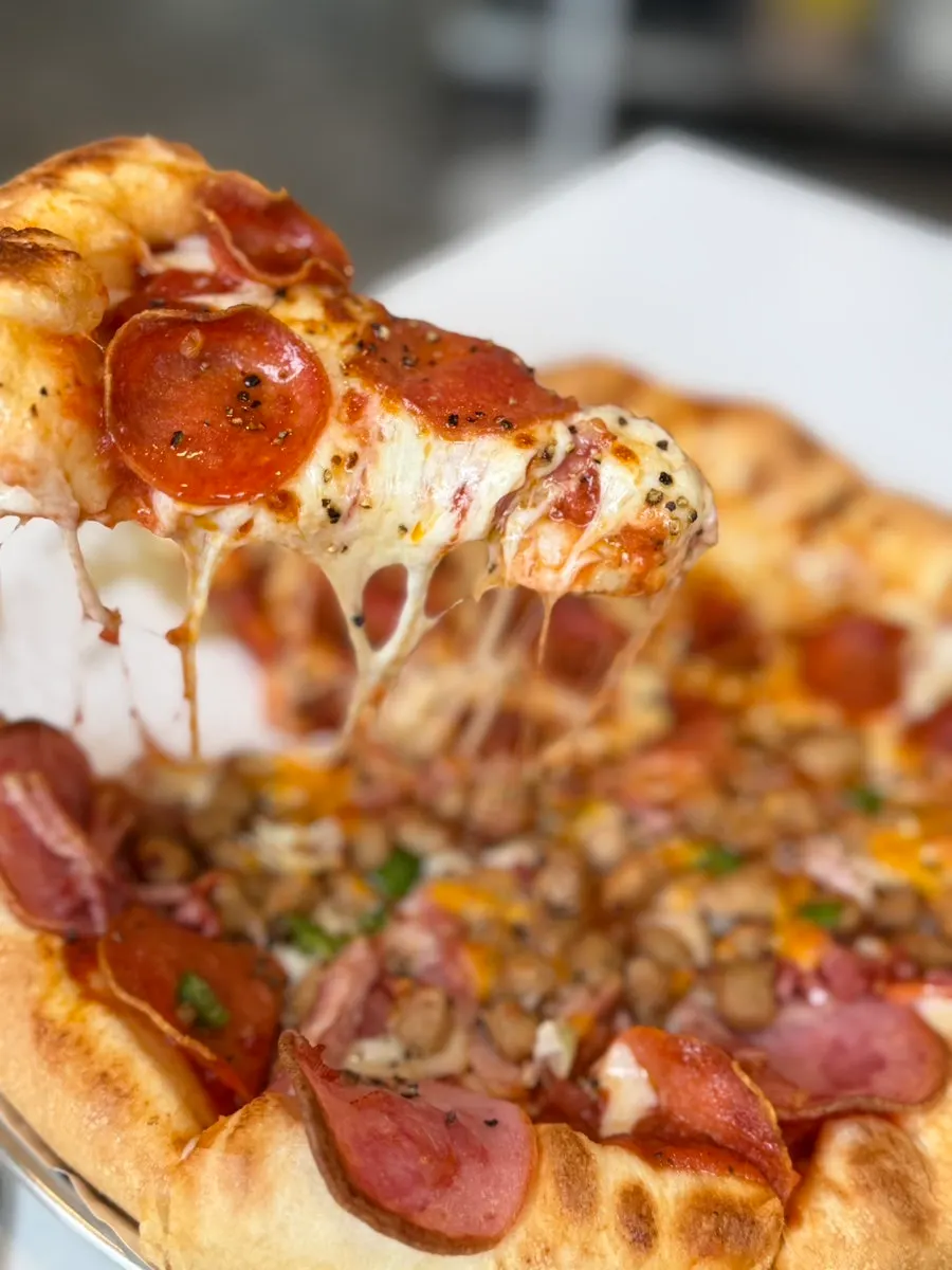 Pepperoni pizza slice with parmesan cheese and garlic dipping sauce