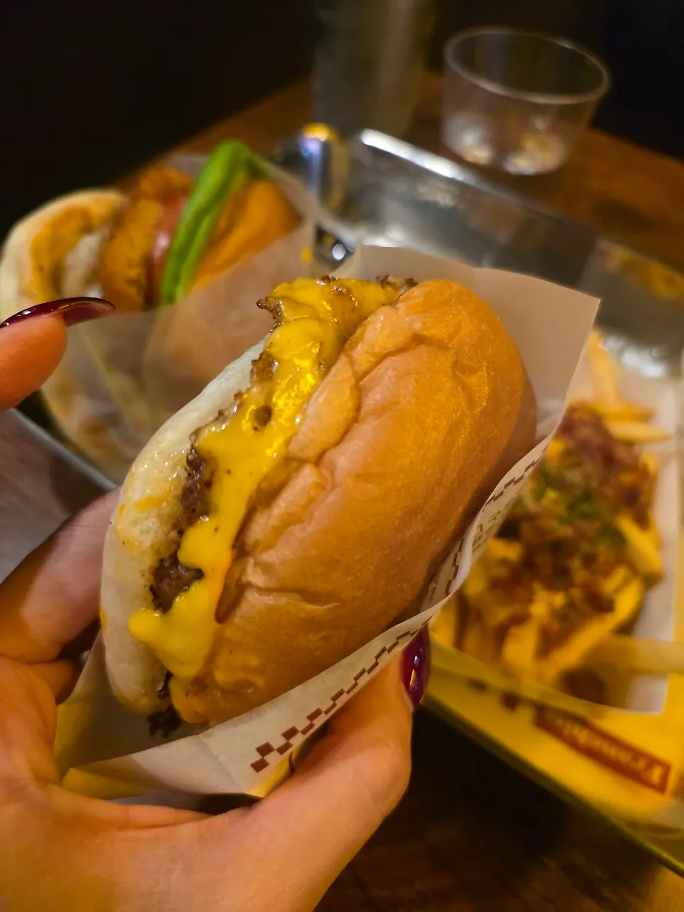 Holding up the sriracha cheese burger by hand