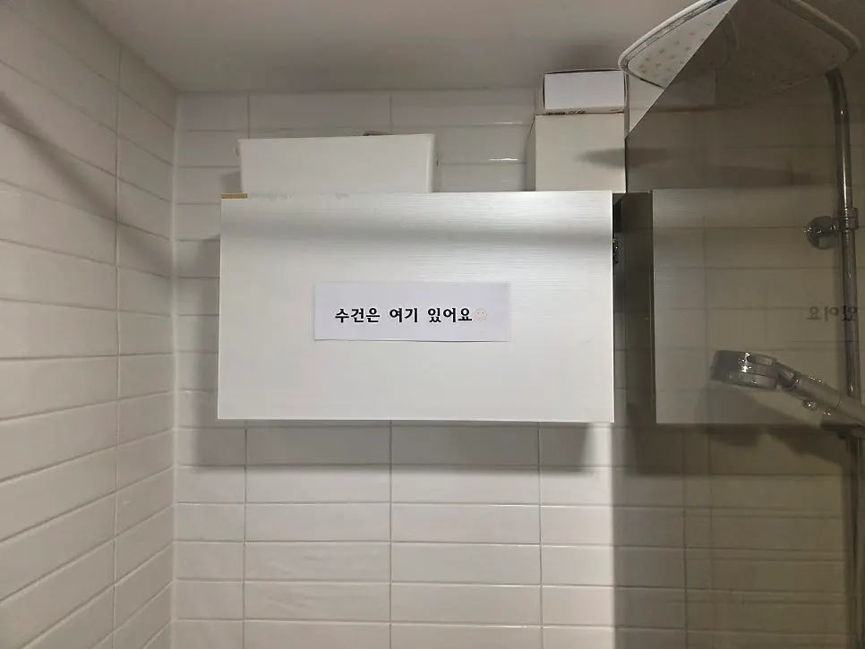 수건 위치 안내문이 붙은 샤워 시설
