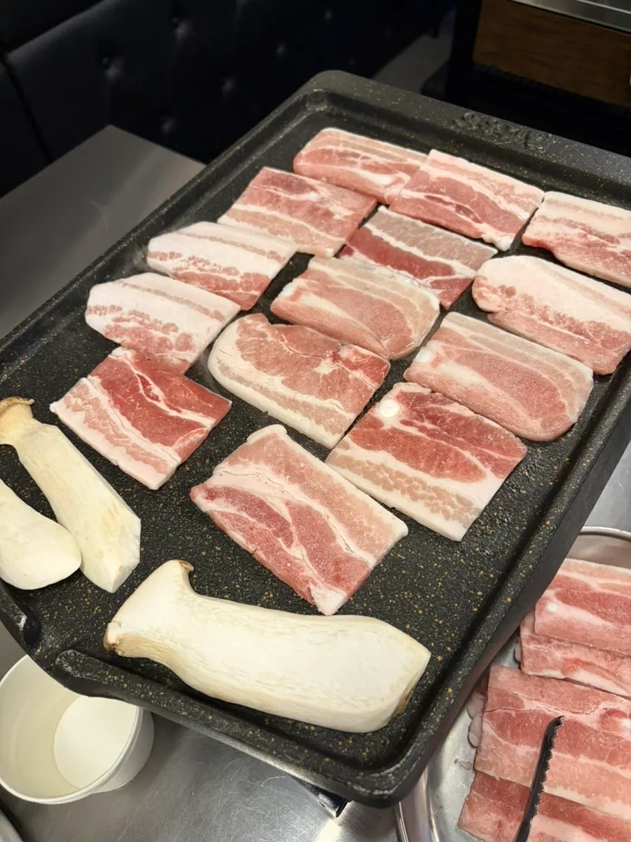 Thin frozen pork belly on the grill