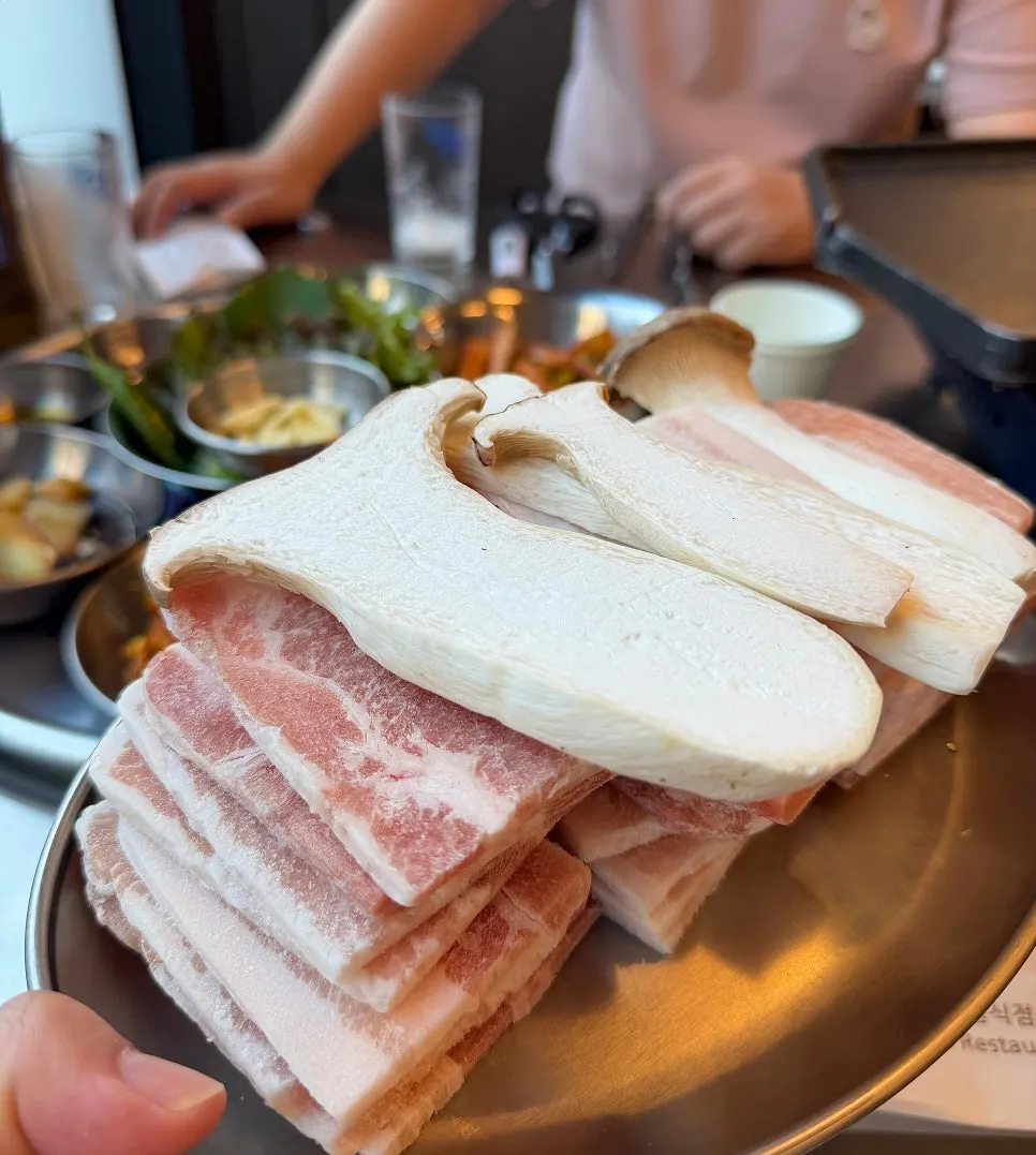 접시에 쌓아 나온 냉동 삼겹살 4인분