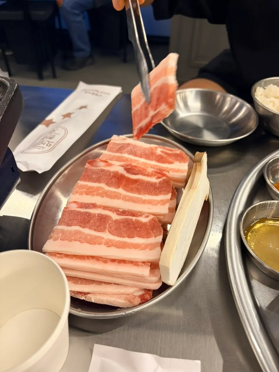 Thin-sliced frozen pork belly on the grill