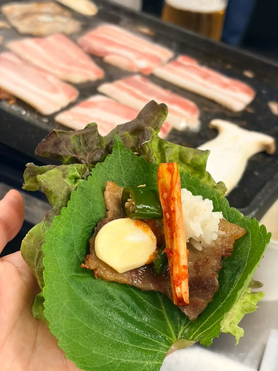 Naengsam wrap topped with garlic and shredded scallion