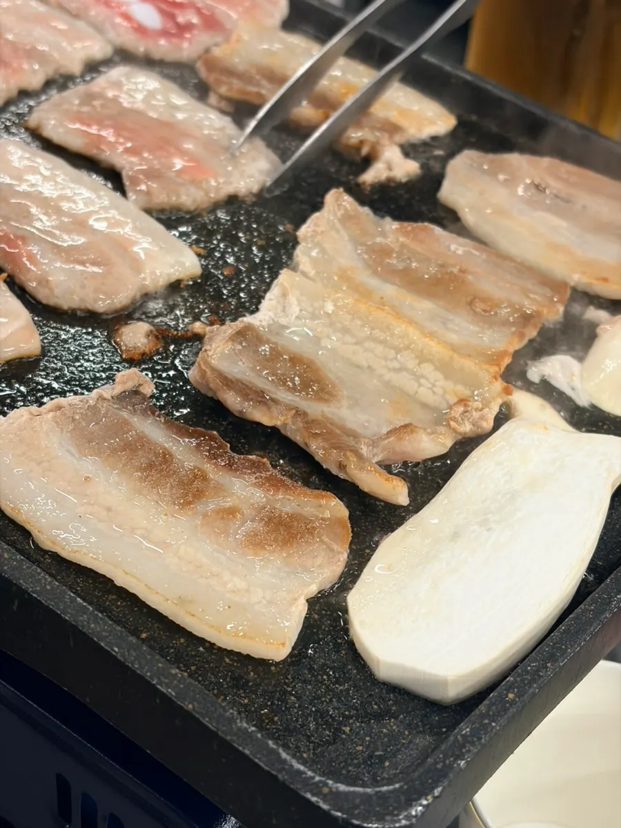 Draft beer glass beside golden-grilled naengsam