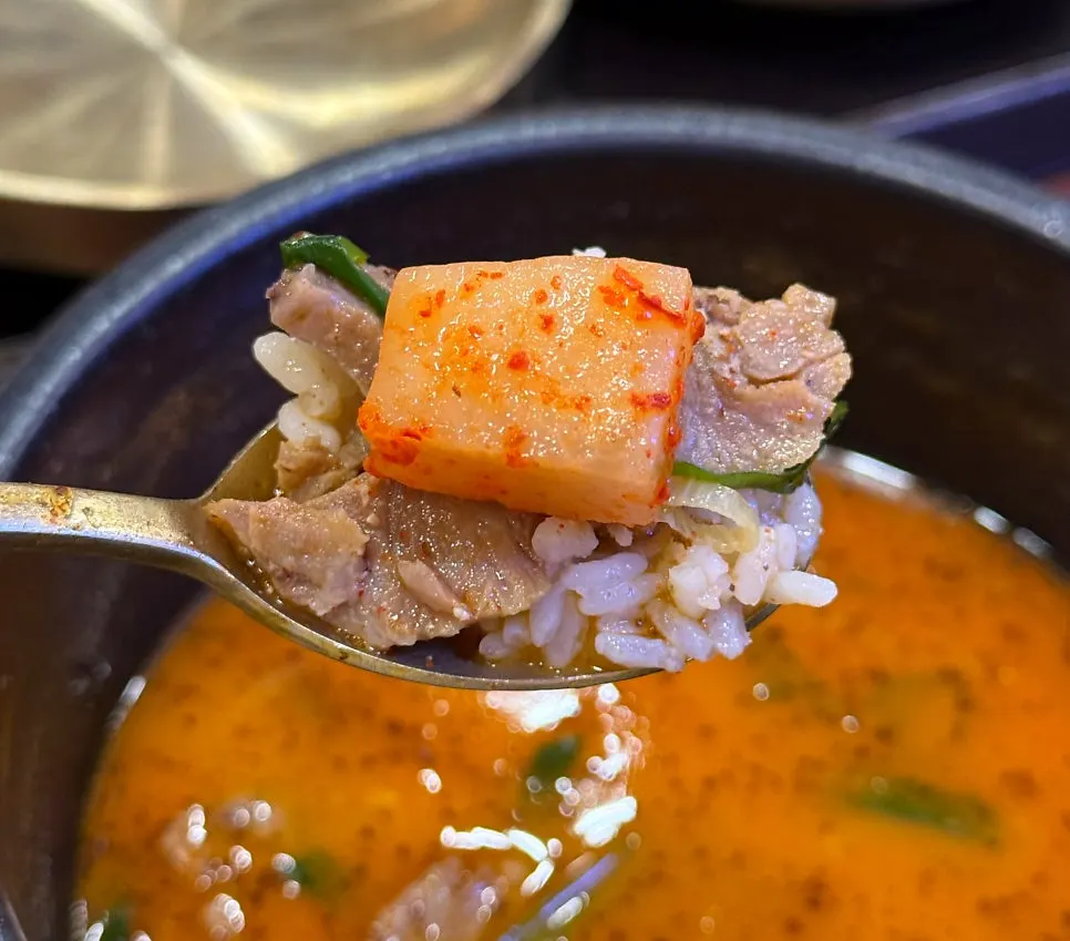 깍두기를 올린 순대국 한 숟갈