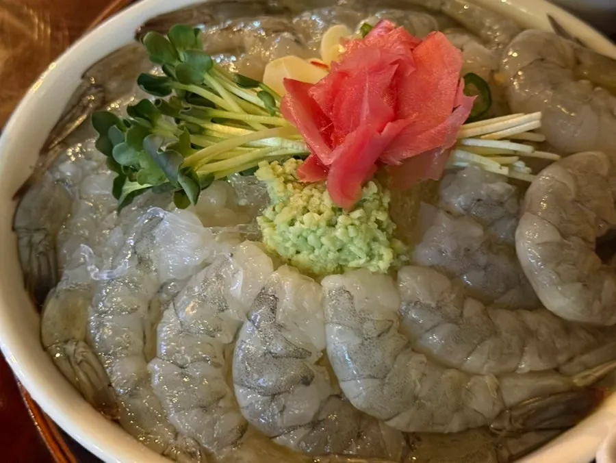 A single glossy piece of raw shrimp sashimi