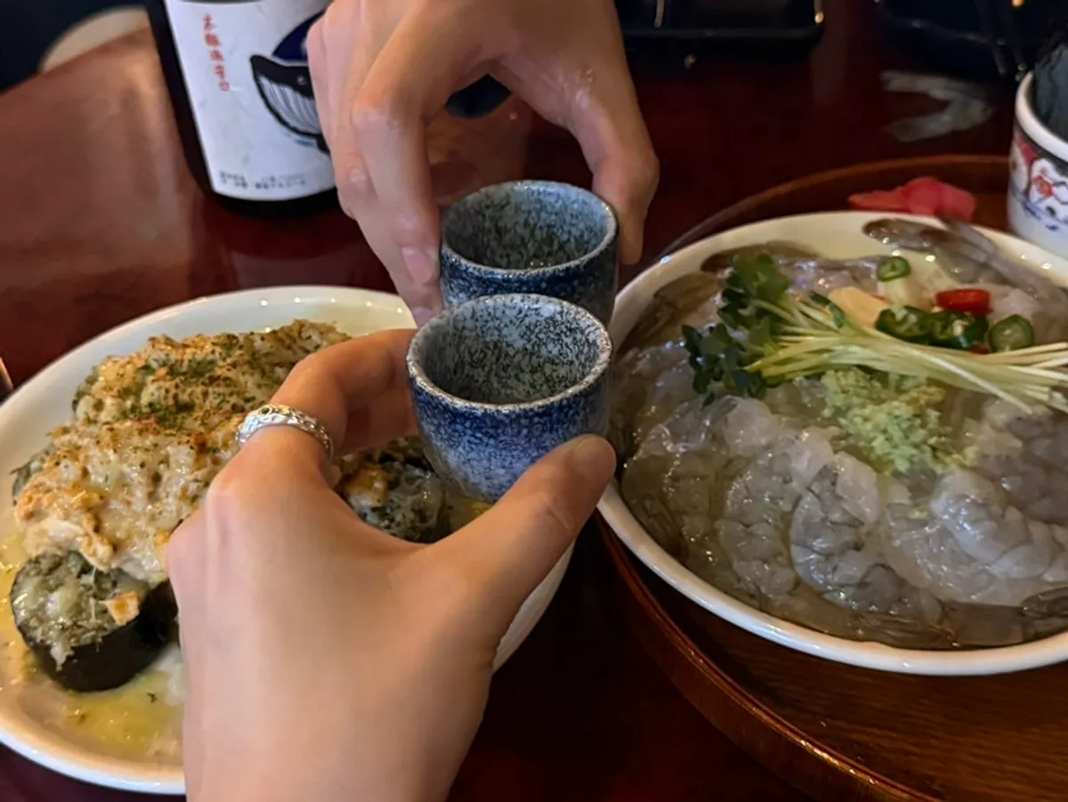 Clinking sake glasses in a toast