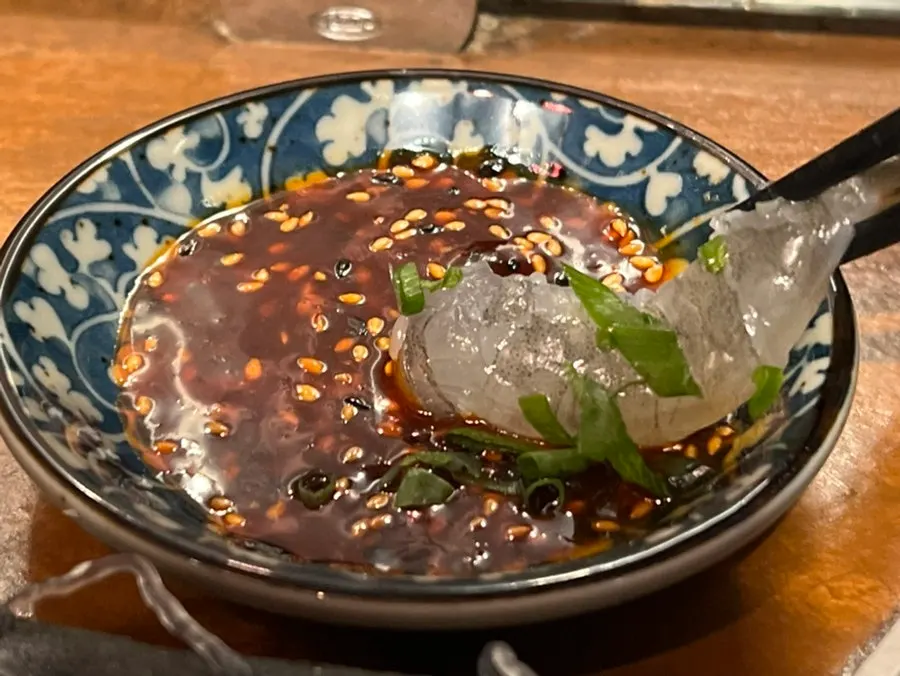 Raw shrimp sashimi dipped in spicy sauce