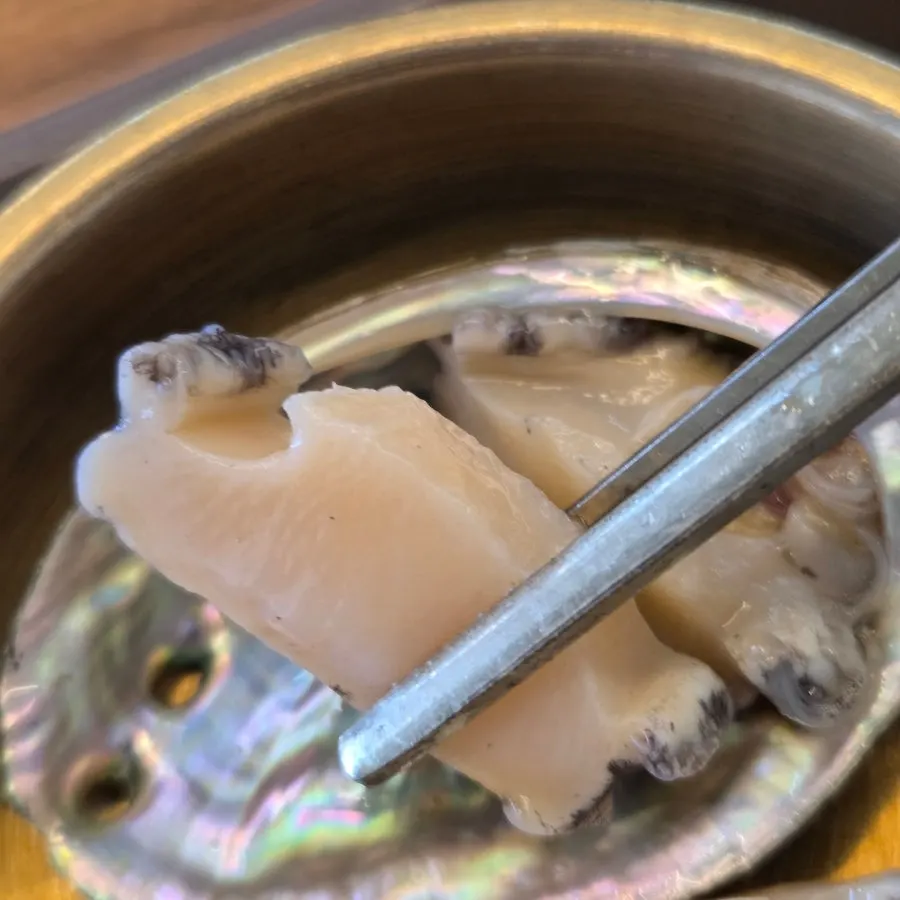 A whole blanched abalone served as a side dish