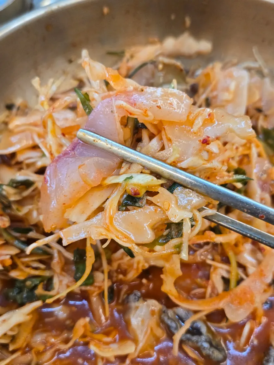 一筷子夾起生魚片與蔬菜