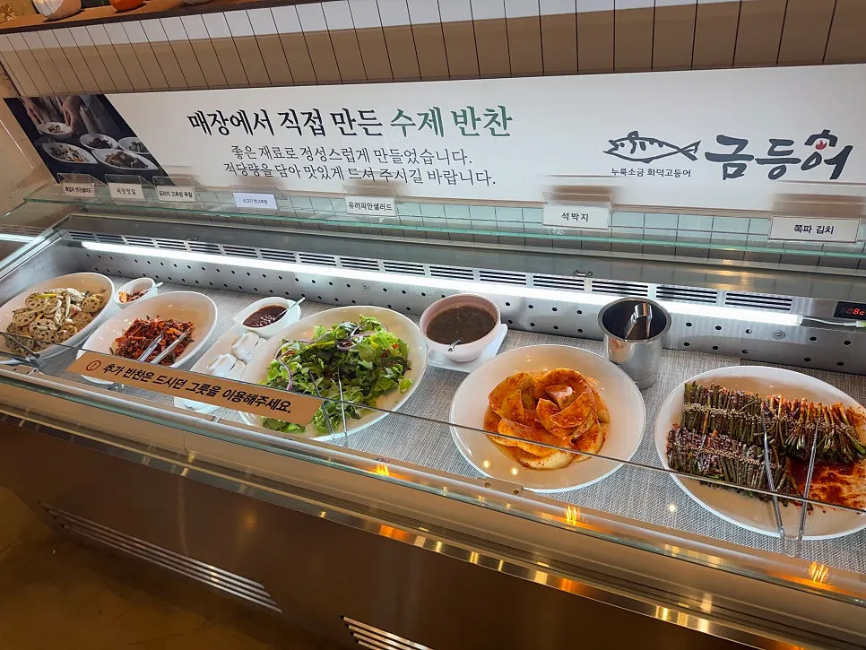Spread of Geumdeungeo banchan including japchae and seaweed salad