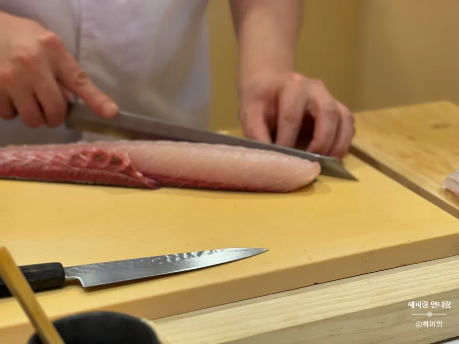 The chef shaping nigiri across the counter