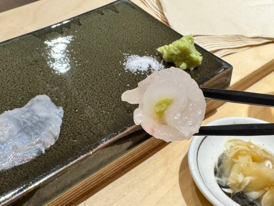 Two pieces of flounder sashimi served with salt and wasabi