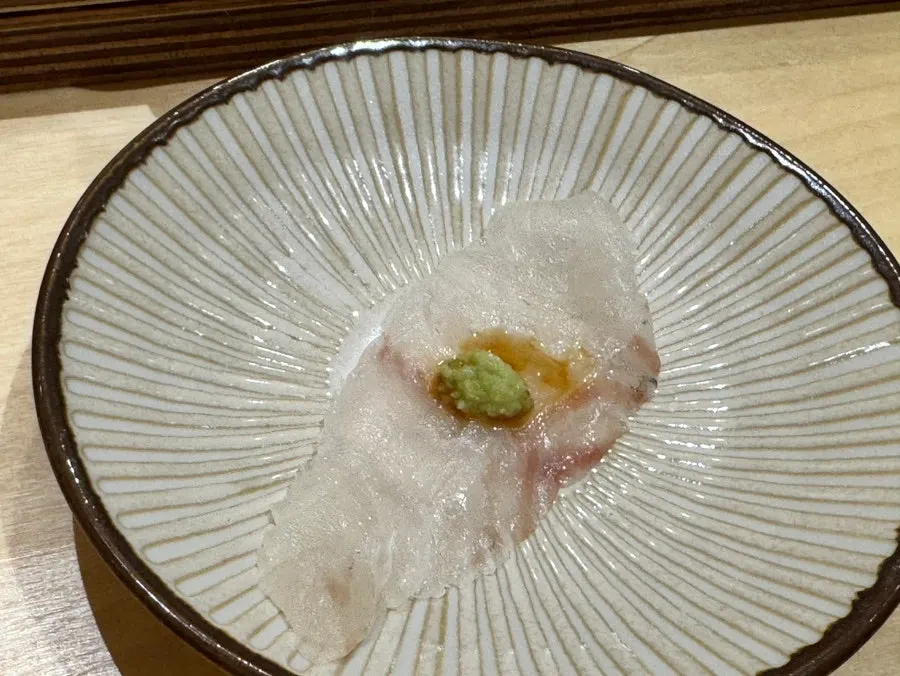 Flounder sashimi dipped in soy sauce and wasabi