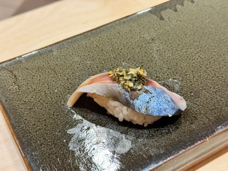 Mackerel nigiri topped with shiso and pickled ginger