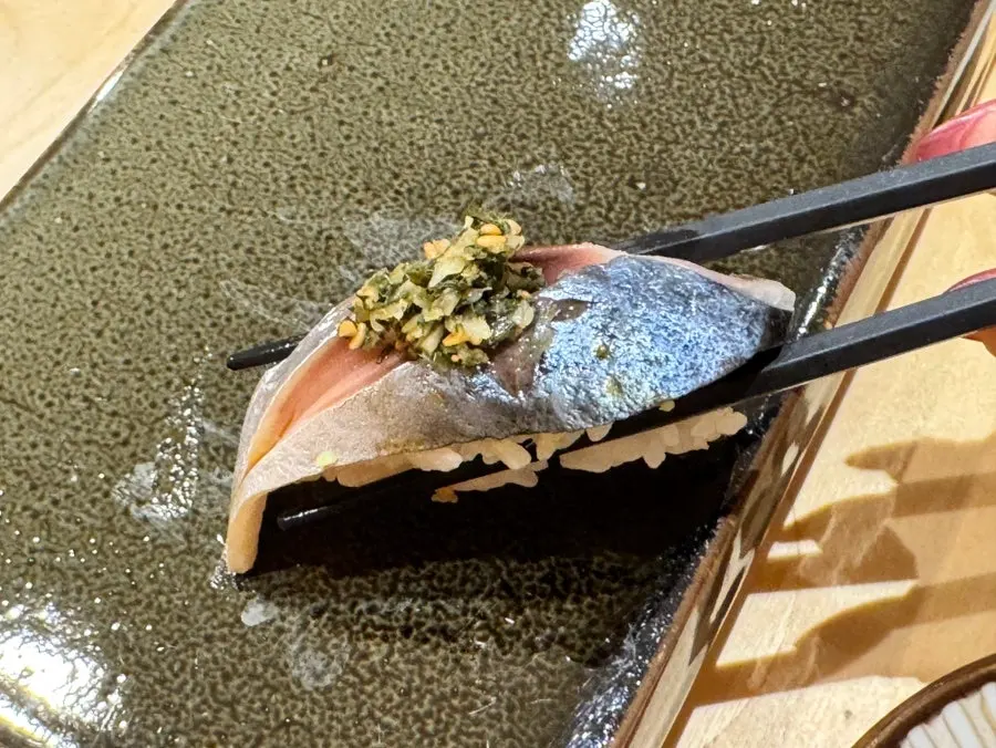 Mackerel sushi topped with sesame and pickled ginger