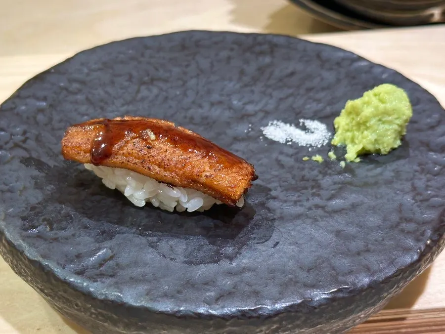 Mackerel sushi topped with shiso and pickled ginger