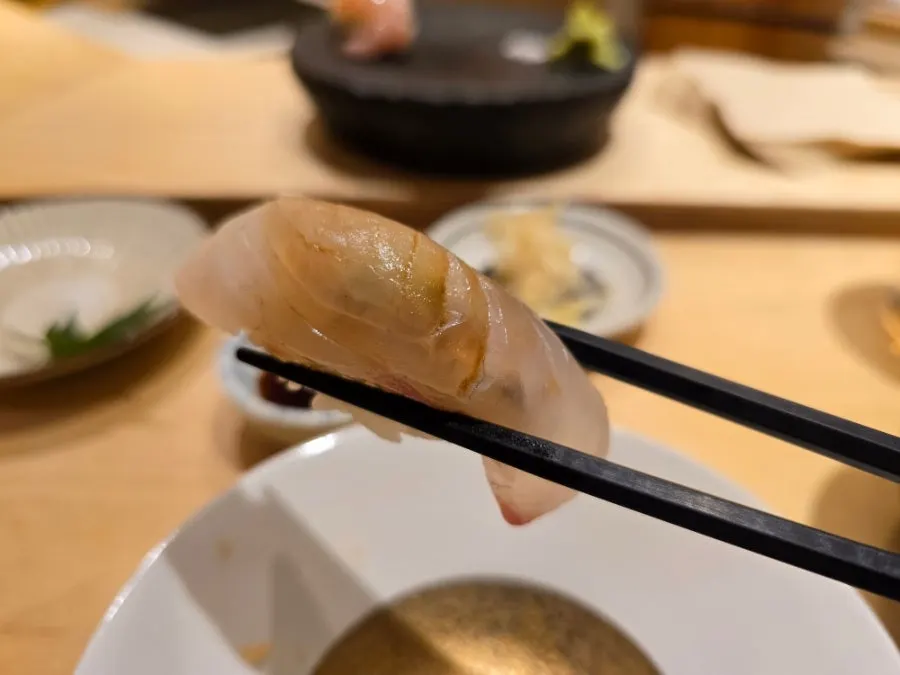 A piece of sushi served by the chef at Sushi Hibi