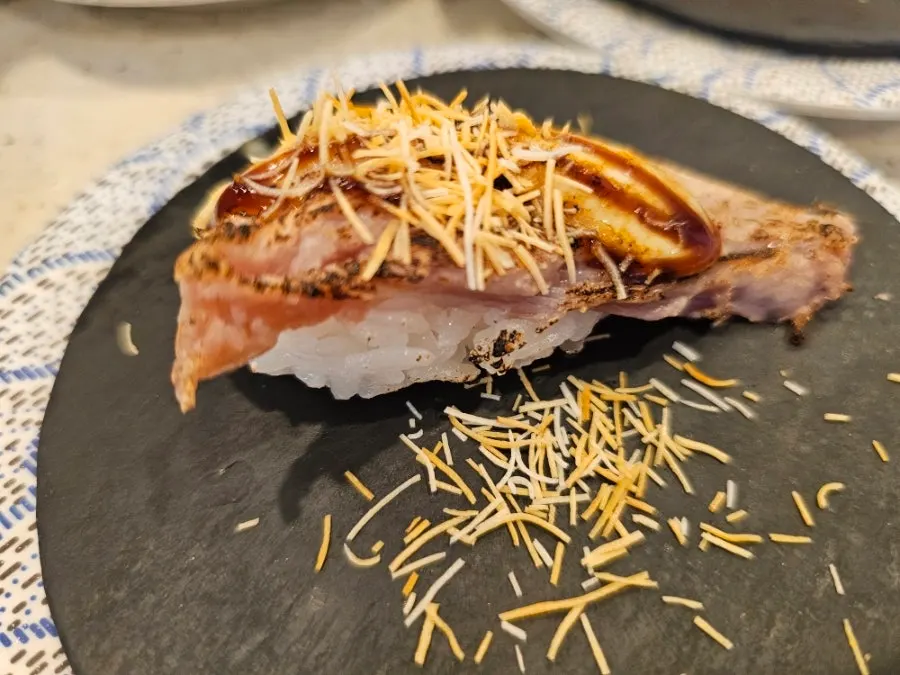 A plate of salmon toro scallion-chip sushi