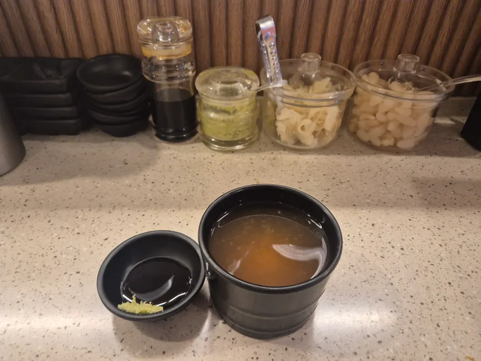 Table setting with miso soup, soy sauce, and pickled radish