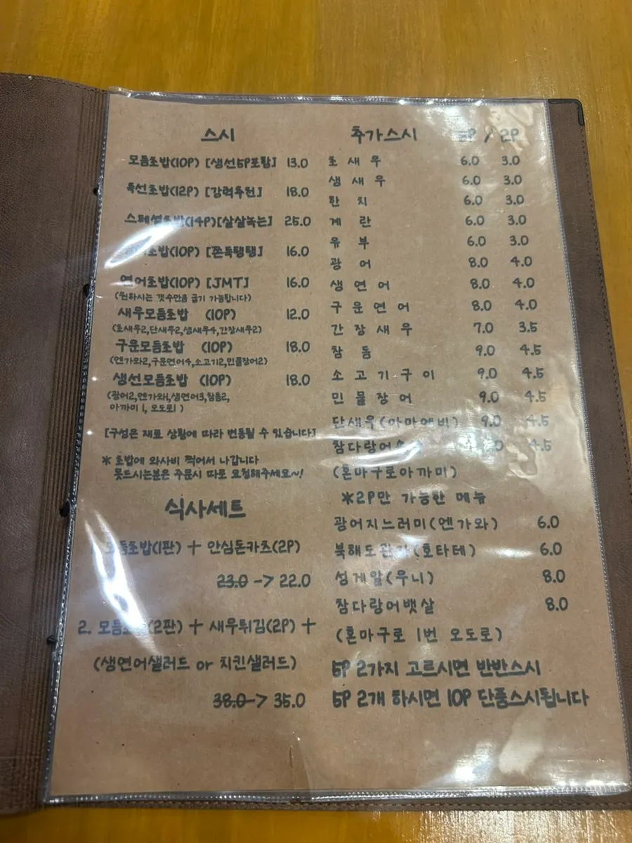 Sushi Naru menu board listing set menus and extra pieces