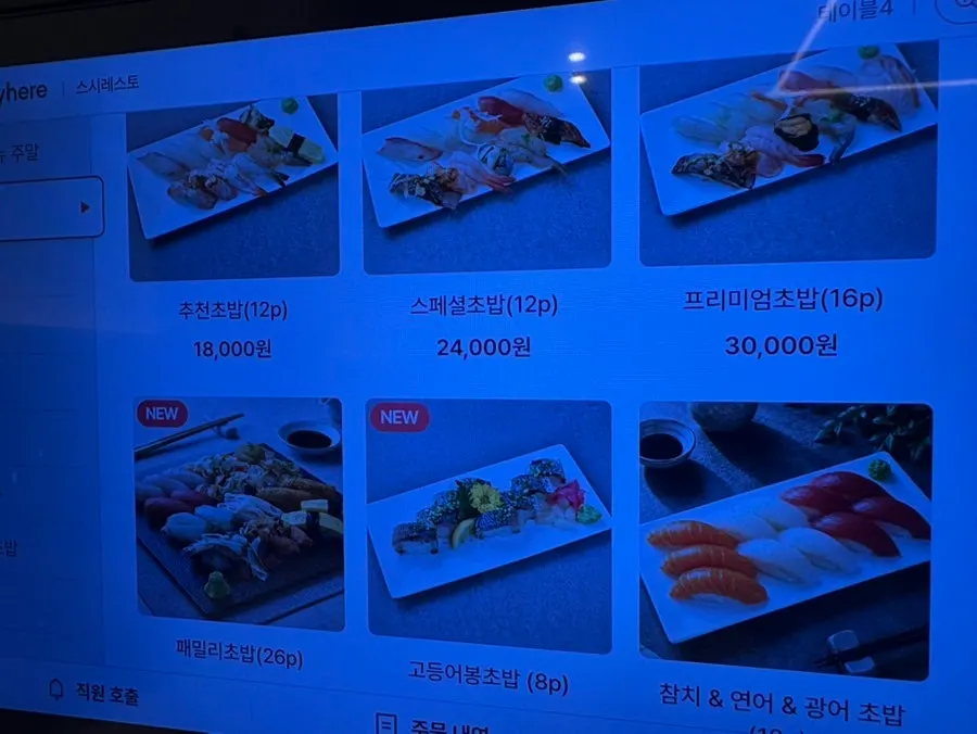 A menu board listing sushi, sashimi, and rolls