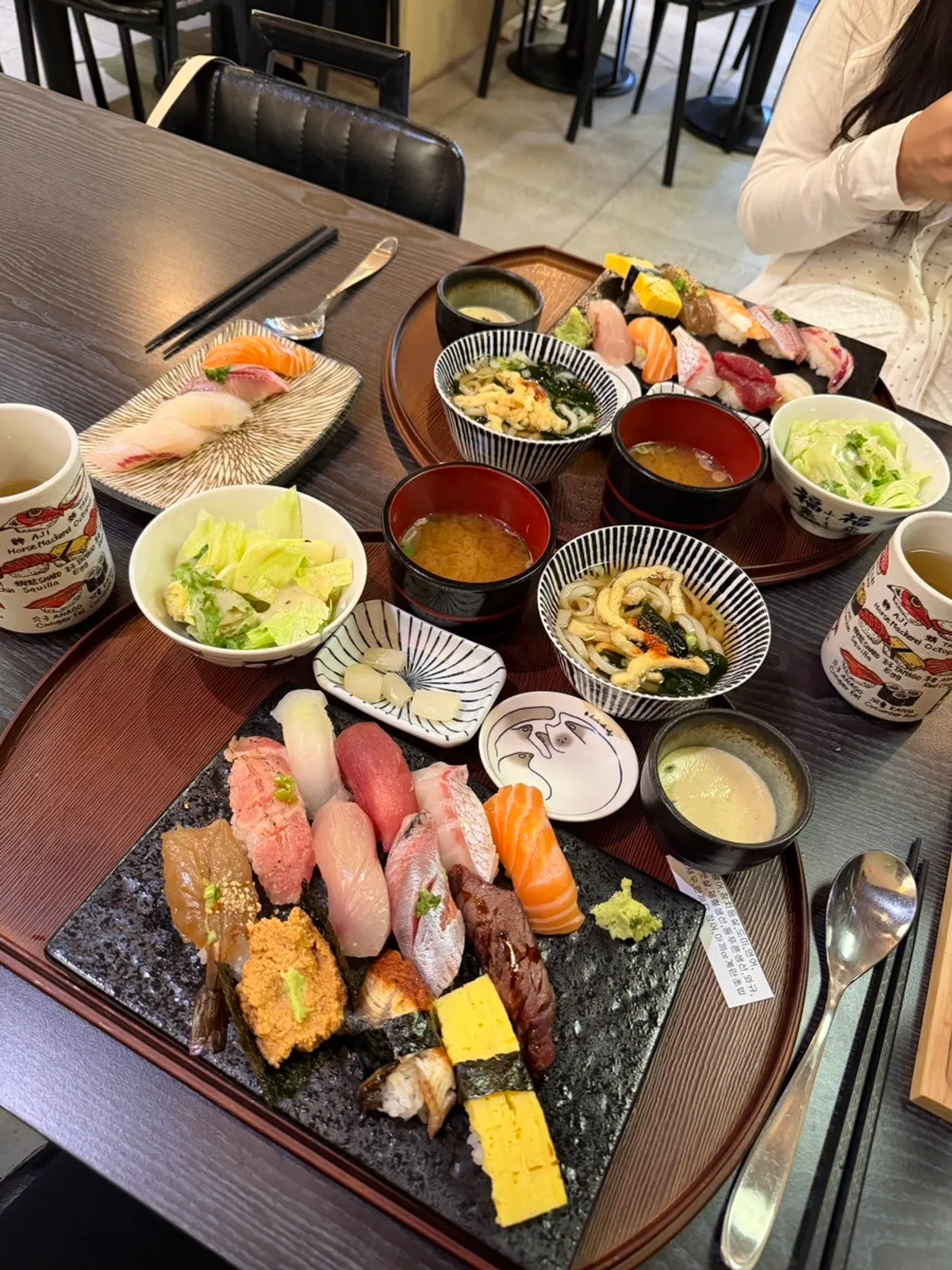 Sushi table setting with a note listing the fish types
