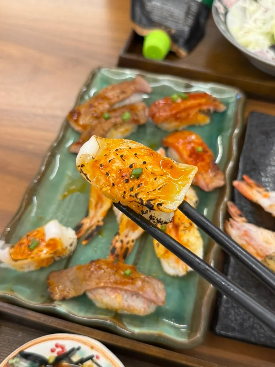 Flame-seared sushi topped with spicy sauce