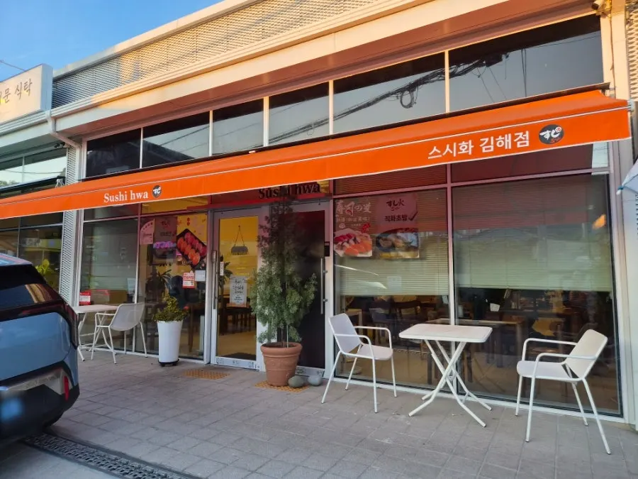 Sushi Hwa's storefront on Bonghwang-ri-dan-gil in Gimhae, with an orange awning