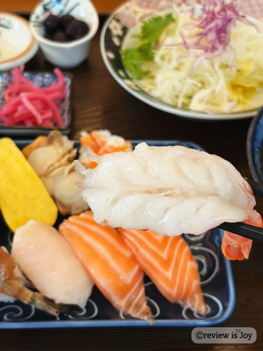 A piece of raw sushi served with wasabi