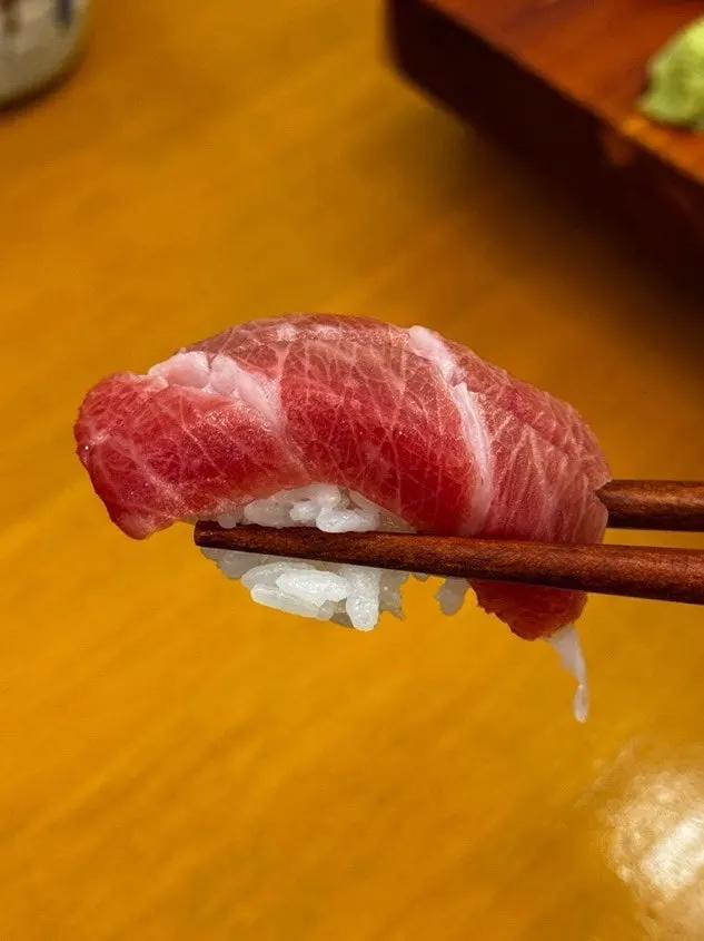 A thick slice of fish on top of the sushi rice