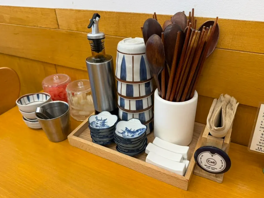 Table setting with utensils, pickled ginger, and rakkyo