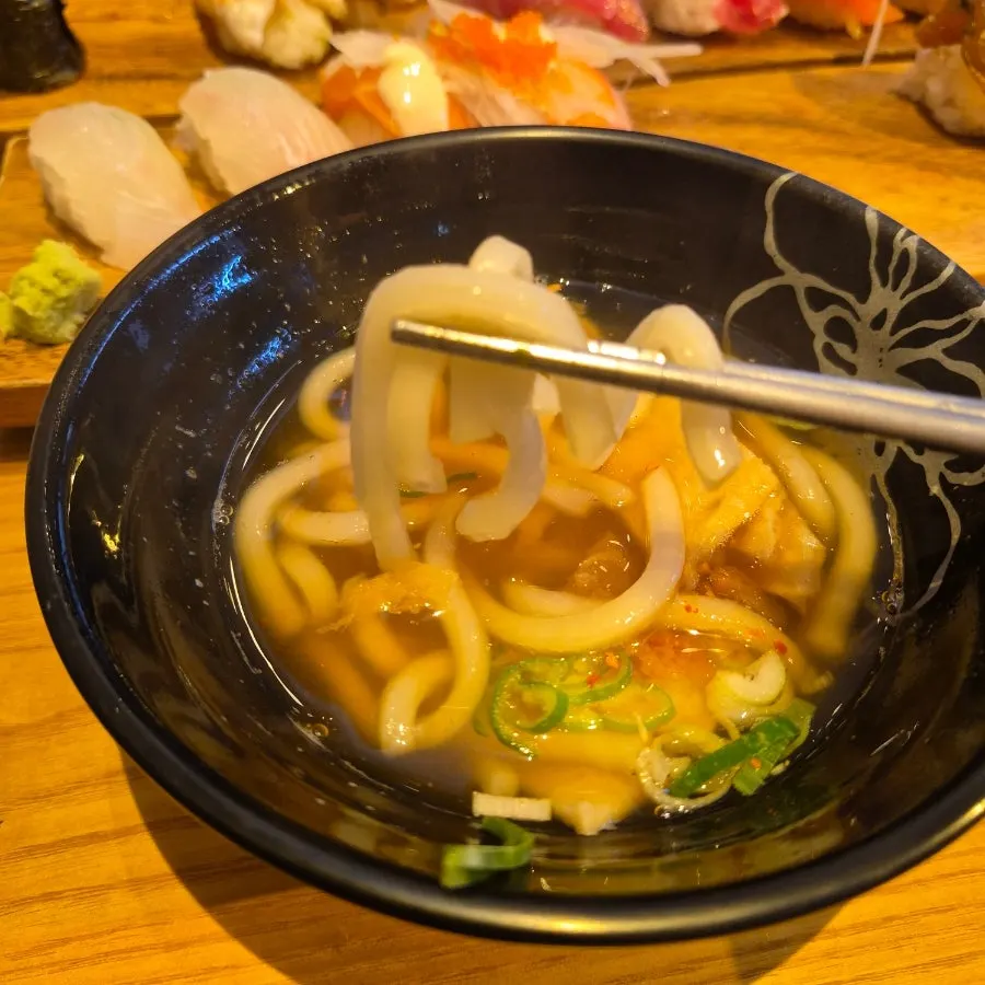 Lifting up udon noodles from the broth